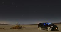 The constellation Ursa Major looms over a GPS-equipped survey vehicle and a ground station to its left at El Mirage Dry Lake. By comparing elevation readings from both GPS sources, researchers can build an elevation map to precisely calibrate the laser altimeter for ice thickness measurements.