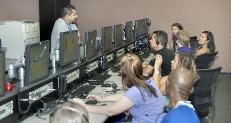 NASA Dryden test range operations technician Daniel Burgdorf explains the various flight test data parameters displayed on screens that are monitored by flight test engineers to AREE program teachers in one of Dryden's control rooms