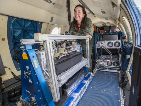 Laura Judd, postdoctoral researcher at NASA Langley, prepares for a LISTOS science flight on the center's HU-25 aircraft. GeoTASO, a remote-sensing instrument that observes reflected sunlight to measure atmospheric trace gases and aerosols over a wide area, is visible in the foreground. Credits: NASA/David C. Bowman