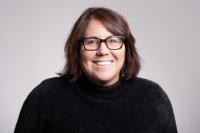 Profile picture of Cynthia Hall (she/her). Cynthia has brown hair with glasses. She has on a black sweater.